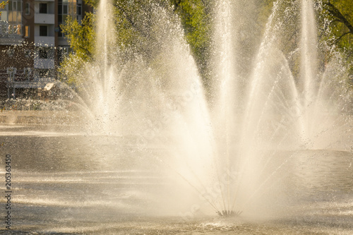 Spray from the fountain in the city as a background photo