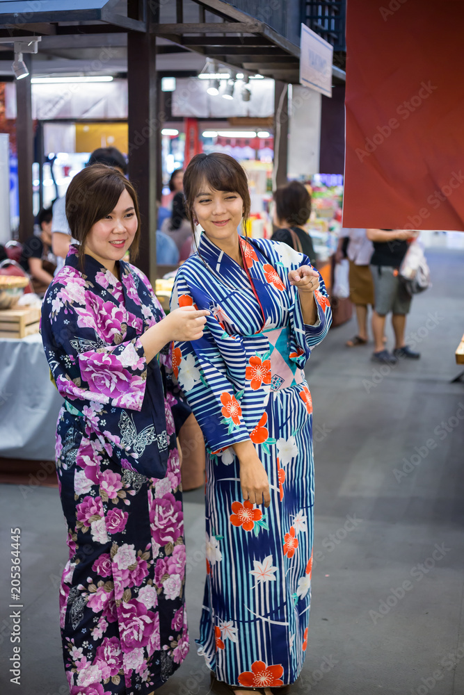 Two young woman wearing japanese traditional kimono enjoy the stroll in the market Japan