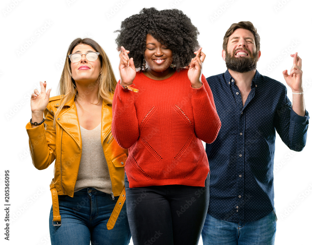 Group of three young men and women with crossed fingers asking for good luck Group of three young men and women with crossed fingers asking for good luck