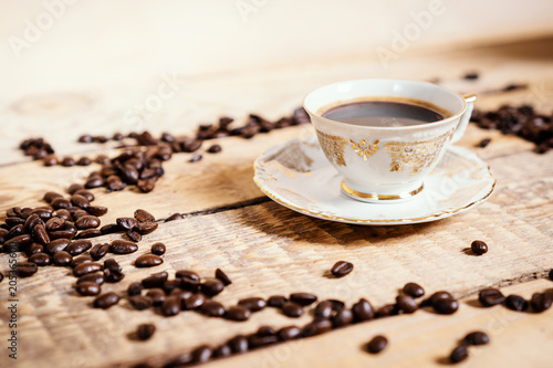 cup of delicious and fragrant coffee on a wooden old table with seeds