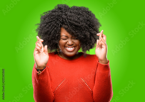 Beautiful african woman with crossed fingers asking for good luck © Krakenimages.com