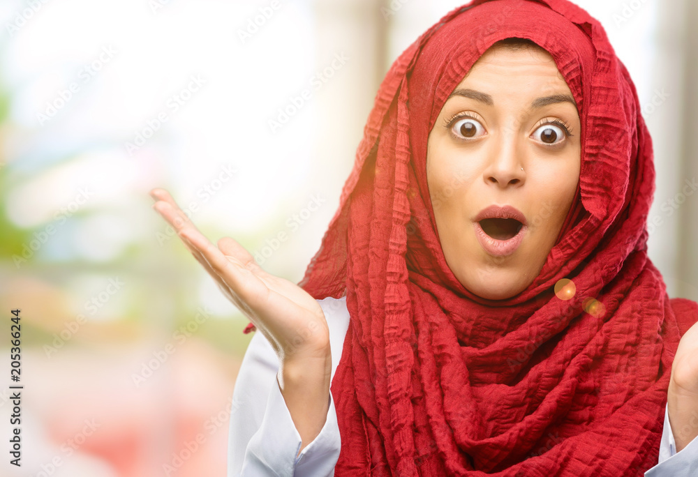 Young arab woman wearing hijab happy and surprised cheering expressing wow gesture Young arab woman wearing hijab happy and surprised cheering expressing wow gesture