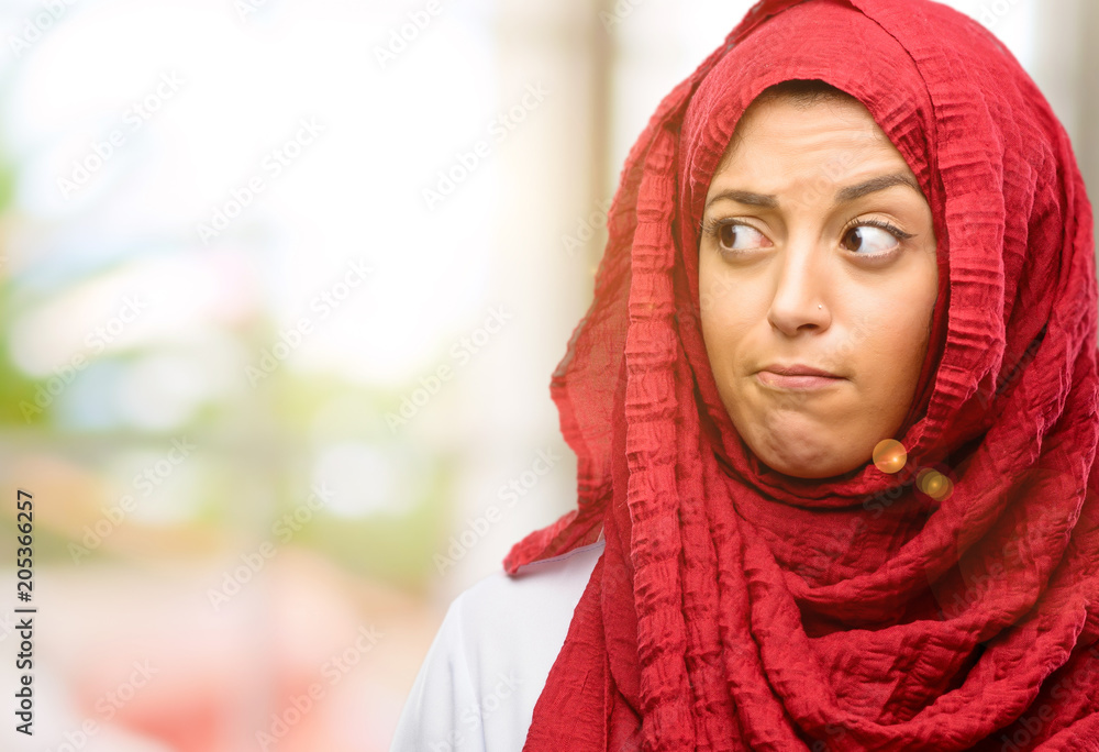 Young arab woman wearing hijab doubt expression, confuse and wonder concept, uncertain future Young arab woman wearing hijab doubt expression, confuse and wonder concept, uncertain future