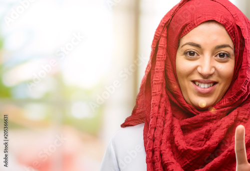 Young arab woman wearing hijab raising his fingers, number two