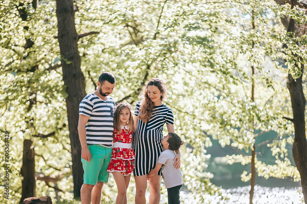Happy family in the park.Pregnant mother with her family on vacation