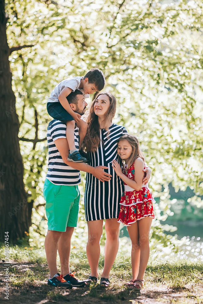 Happy family in the park.Pregnant mother with her family on vacation Happy family in the park.Pregnant mother with her family on vacation
