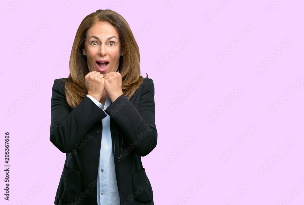 Middle age business woman happy and surprised cheering expressing wow gesture Middle age business woman happy and surprised cheering expressing wow gesture