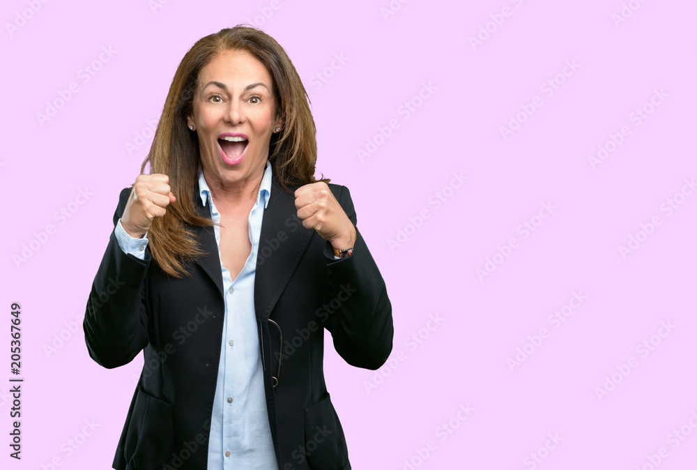 Middle age business woman happy and excited expressing winning gesture. Successful and celebrating victory, triumphant Middle age business woman happy and excited expressing winning gesture. Successful and celebrating victory, triumphant
