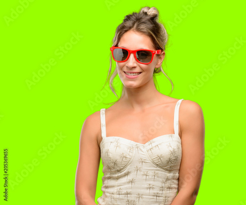 Young beautiful woman wearing red sunglasses confident and happy with a big natural smile laughing