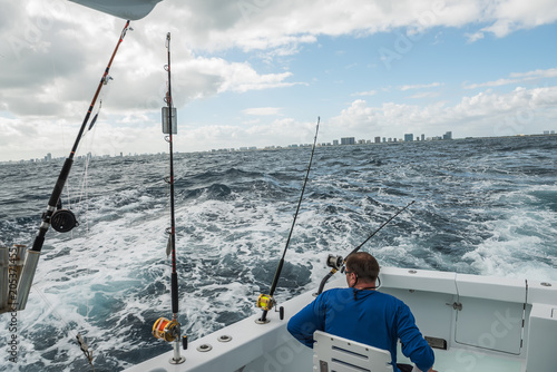 A man in a fishing boat in a stormy ocean with a view of the coast of Miami. fishing in Florida. USA.   © Ann Stryzhekin