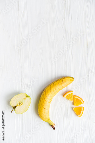 Sliced apple, orange and banana on white photo