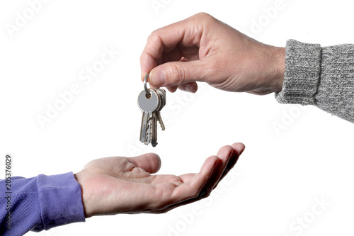 real estate concept: one man's hand giving and one receiving keys door