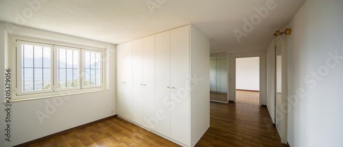 Spacious rooms with large white wardrobes.