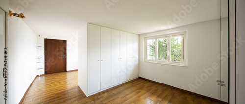 Spacious rooms with large white wardrobes.