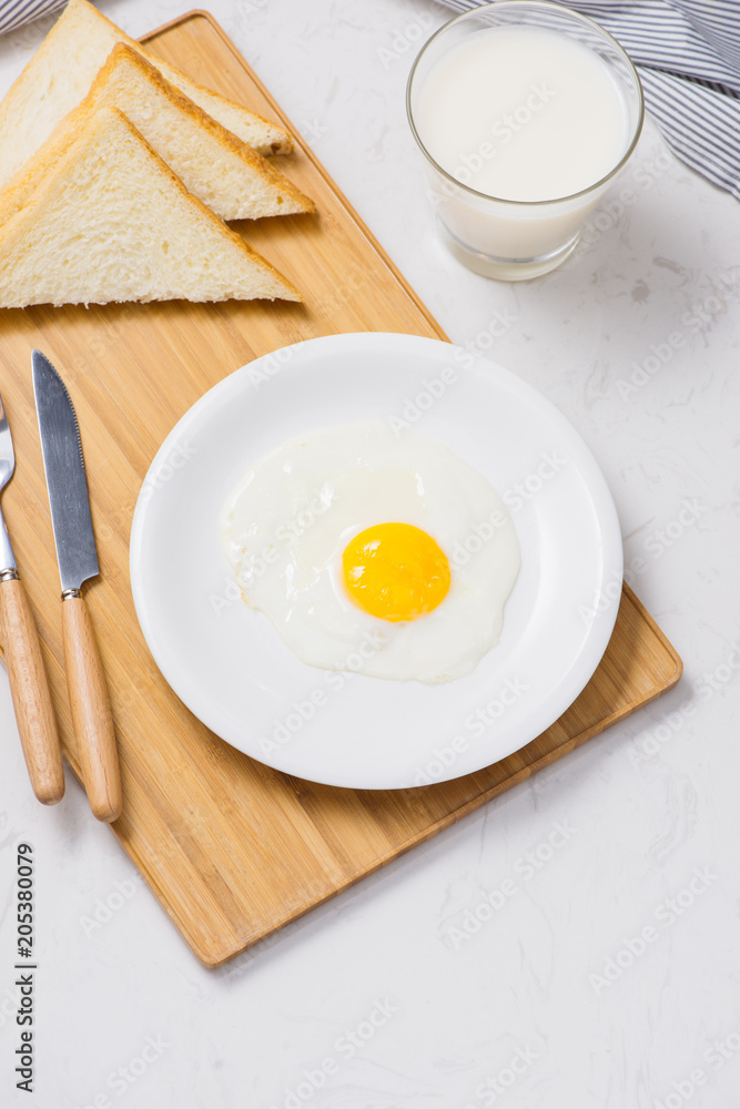Fried eggs with toasts and milk on the table Fried eggs with toasts and milk on the table