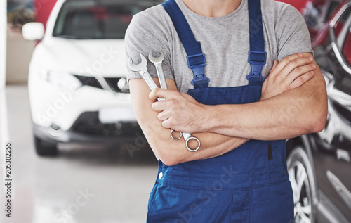 Hand of car mechanic with wrench. Auto repair garage