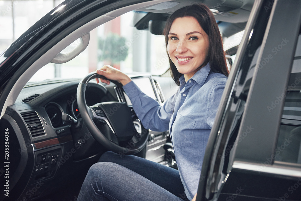 auto business, car sale, consumerism and people concept - happy woman taking car key from dealer in auto show or salon auto business, car sale, consumerism and people concept - happy woman taking car key from dealer in auto show or salon