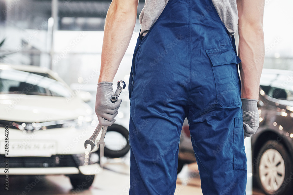 Hands of car mechanic with wrench in garage Hands of car mechanic with wrench in garage