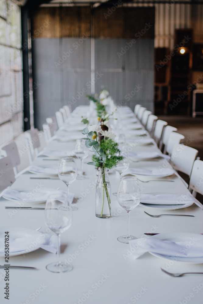 Fototapeta premium White Dining Table at wedding with flowers at beautiful venue