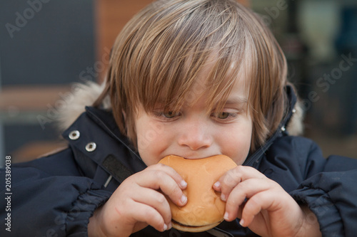 Little boy (5-6) eating hamburger photo