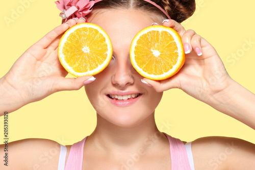 Young girl posing with halves of orange