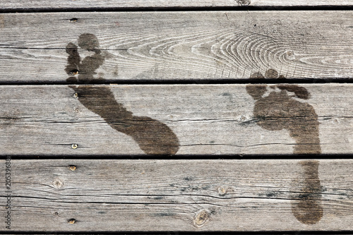 Wall Mural Wet footprints on a wooden jetty / bridge