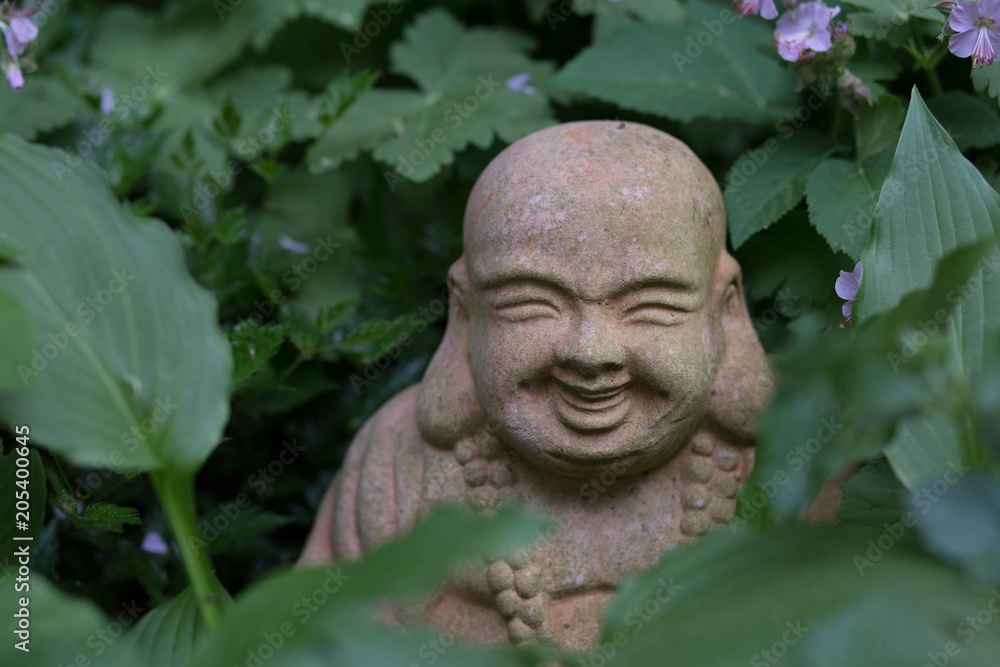 Buddha Statue im Blumenbeet