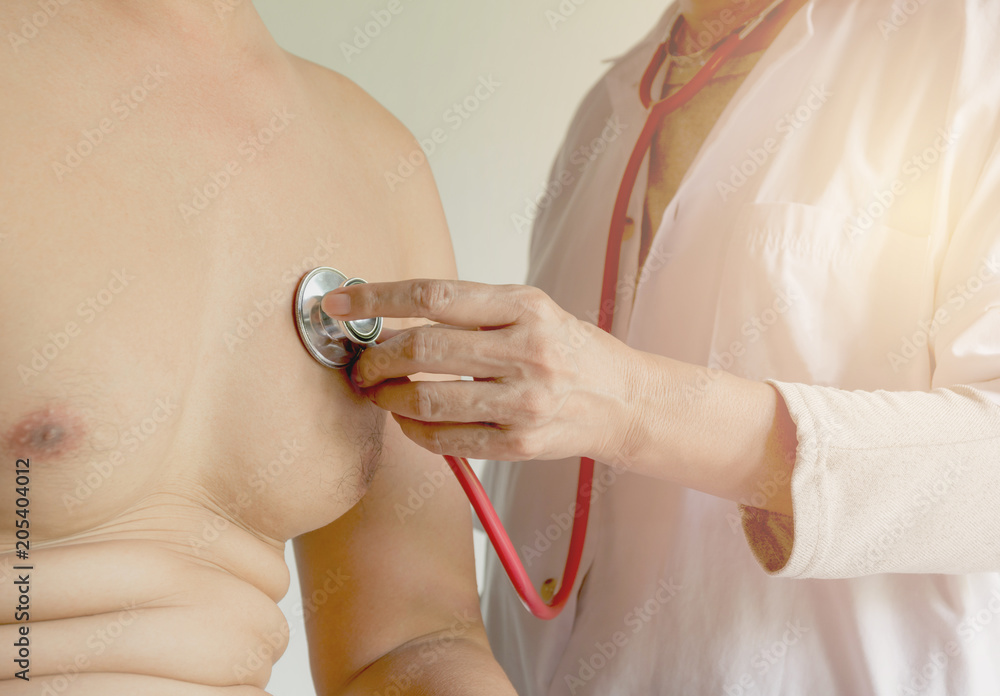 Fototapeta premium Female doctor using stethoscope for check and listen to heart and lungs of patient at a hospital.