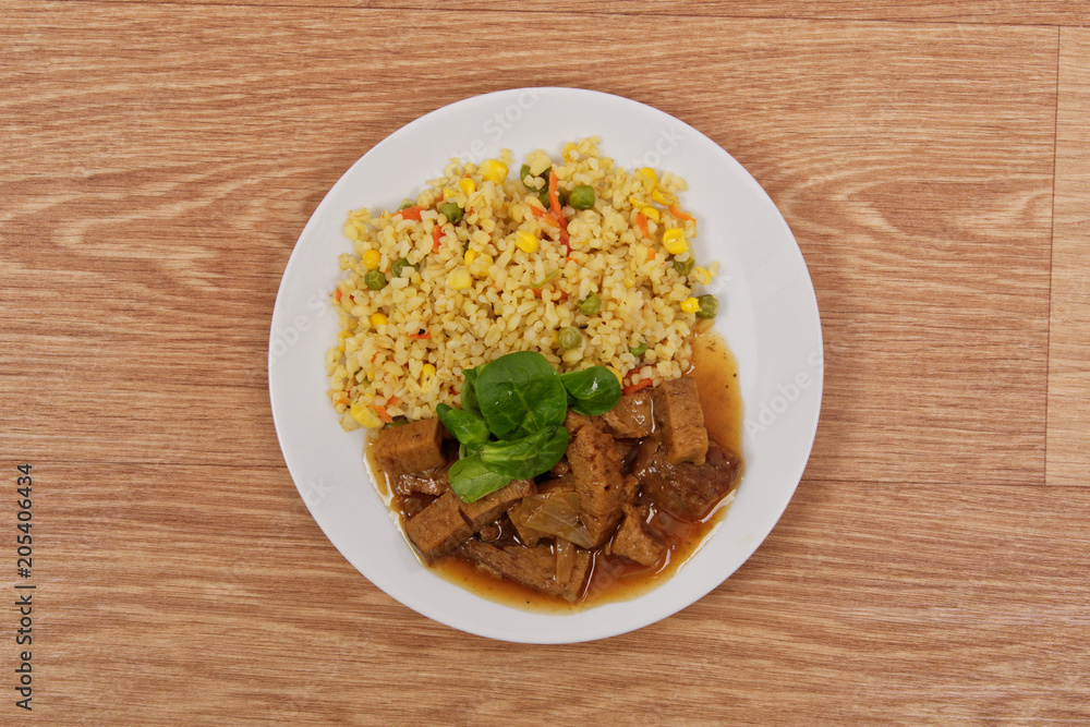Tempeh with tomato sauce and millets on a table Tempeh with tomato sauce and millets on a table