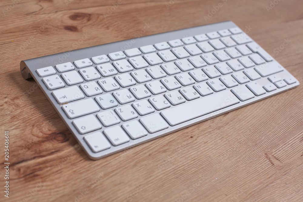 Modern aluminum keyboard on the wooden table in the office Modern aluminum keyboard on the wooden table in the office