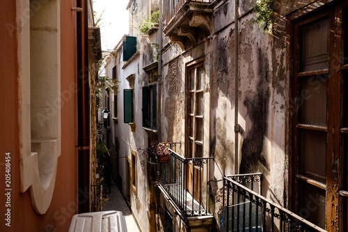 sicilian shutters in a very narrow street, in the morning light