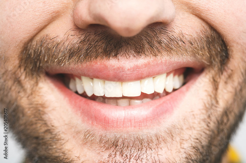 Detailed image of young man smiling with perfect white teeth. Healthy concept. Close-up.