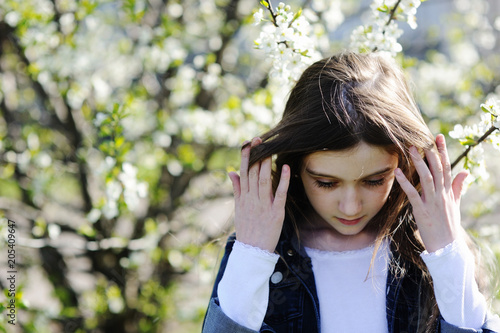 Kid girl in blooming apple garden