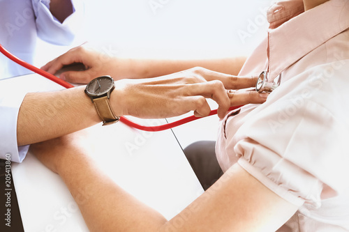 The concept of annual health check, the doctor is checking the rhythm of the heart.