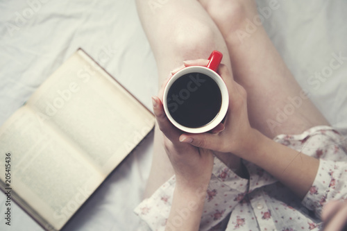 woman hand  cup of coffee and book