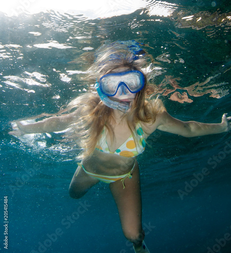 Beautifu girl snorkels in the sea.