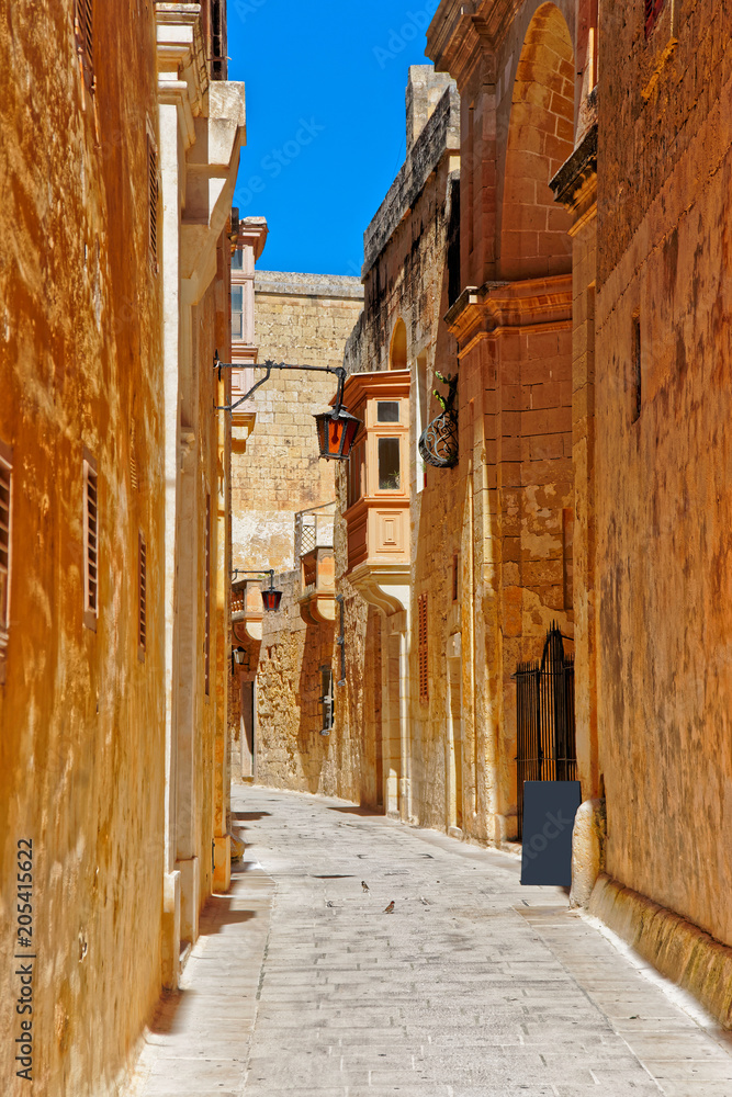 Narrow silent street with lantern in Mdina