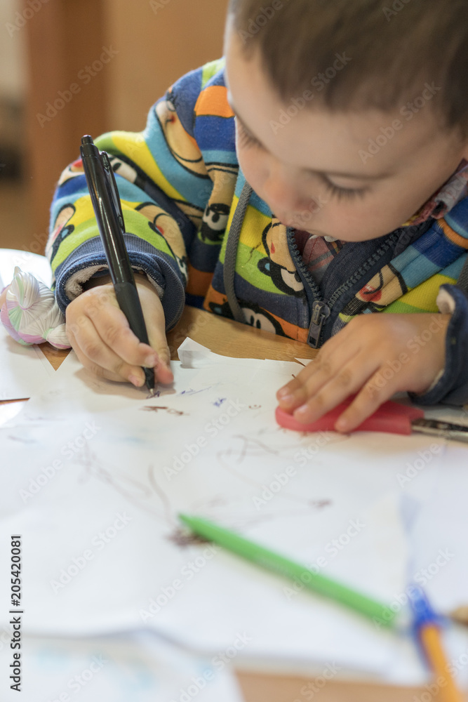 Cute little boy writing something in notebook Cute little boy writing something in notebook