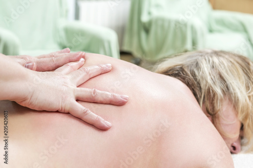 Hands massaging the back, lying on the belly of a woman