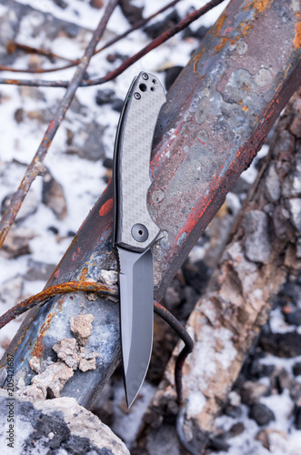 A pocket knife with a black blade. Vertical shot. photo