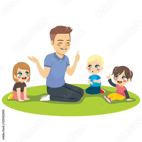 Young male kindergarten teacher explaining lesson to attentive kids sitting on floor