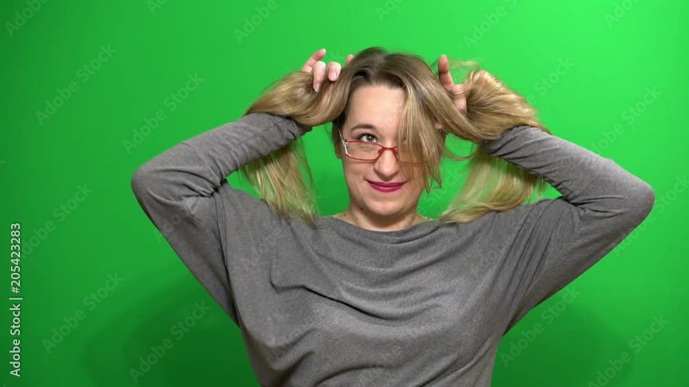 Young girl posing. Good mood. Performs arbitrary rhythmic movements. Plays with hair. Background green screen. Young girl posing. Good mood. Performs arbitrary rhythmic movements. Plays with hair. Background green screen.