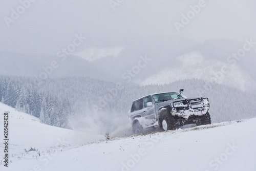 SUV rides on a winter mountians driving risk of snow and ice, drifting