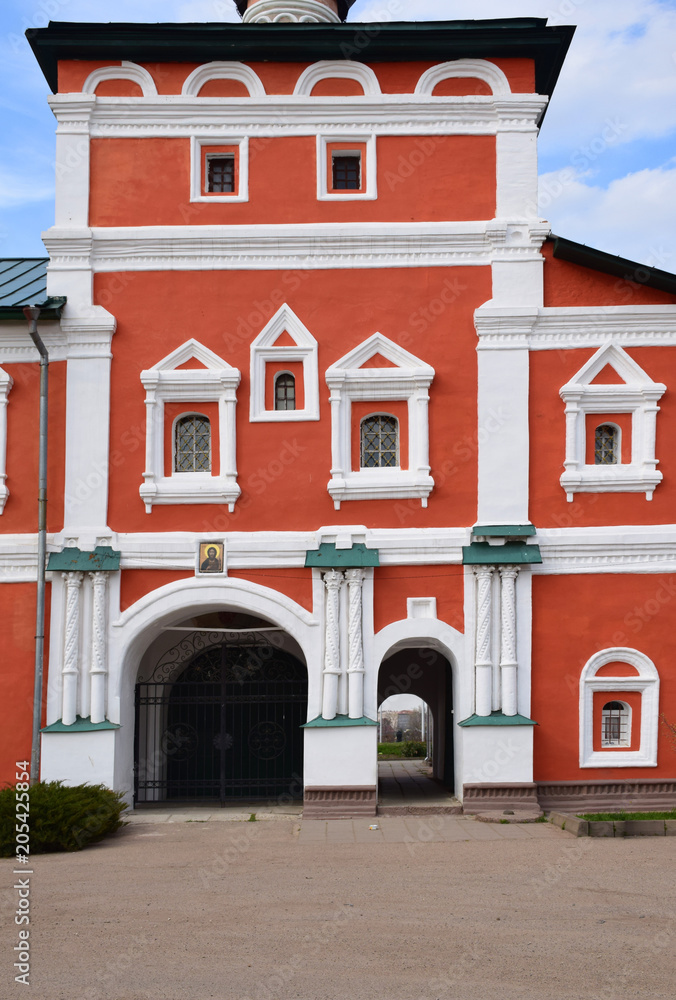 The southern facade of the Church of the Ascension is adorned with: columns and arches of gates, window frames, white pilasters and a pattern on the basement of the building. Russia, Vyazma, April 201