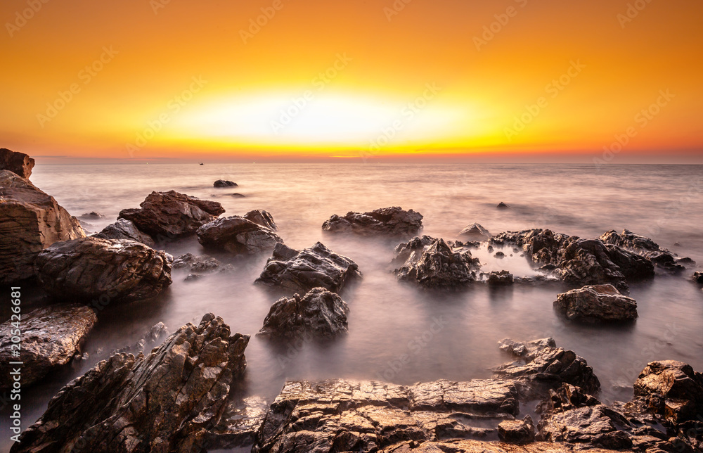 Long exposure rock on the beach at sunset