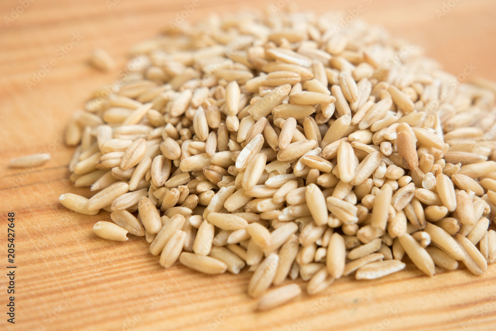 heap raw oats in wooden background. Close up. heap raw oats in wooden background. Close up.
