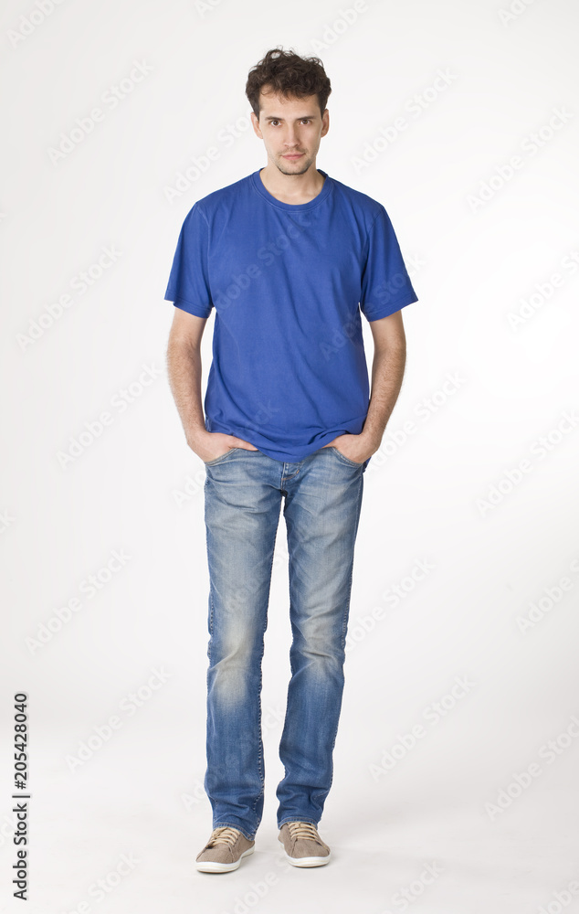 Attractive guy pointing his hands in pockets and posing to camera Attractive guy pointing his hands in pockets and posing to camera