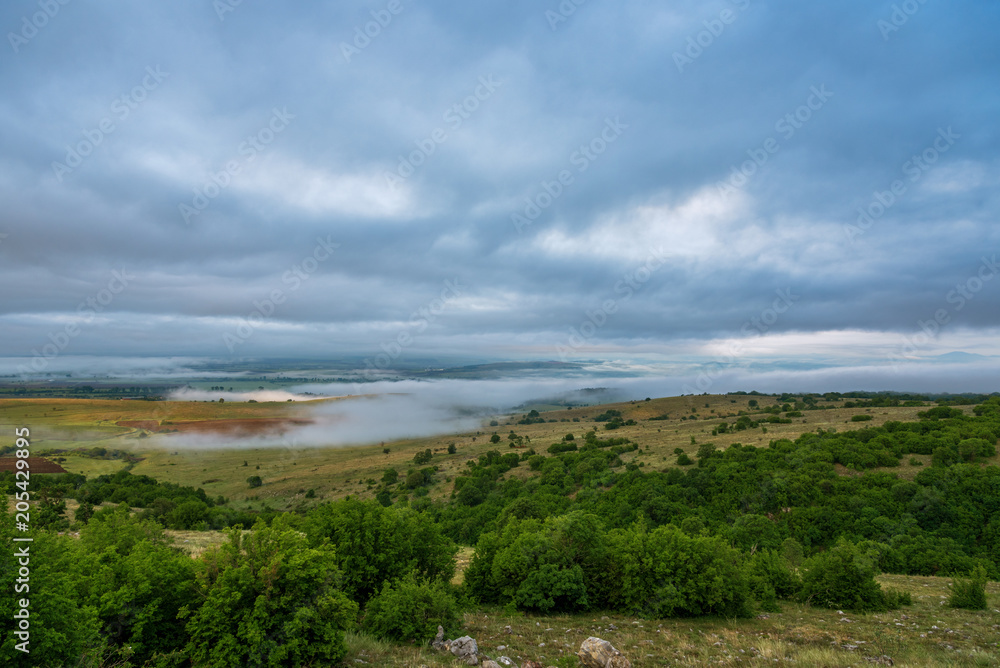 Aerial view mist hovering across a valley. Aerial view mist hovering across a valley.