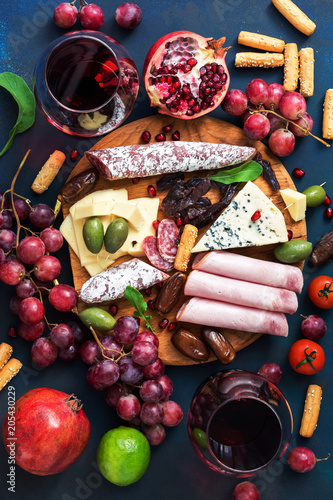 Fototapeta Naklejka Na Ścianę i Meble -  A variety of appetizer with red wine.Various sausages and cold meat, cheese with mold, fruit. Top view, flat lay