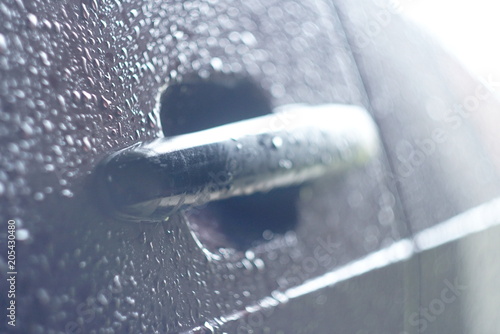closeup of rain drops on car handle 